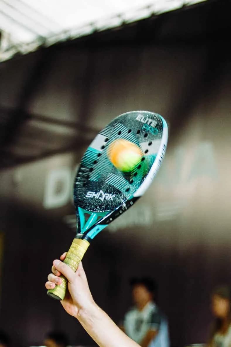 Une raquette de padel frappe une balle en plein vol